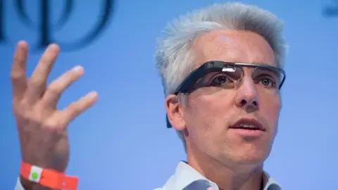 PA Wire A man on stage wearing Google's initial attempt at smart glasses, which feature a prominent wire across the brow and a small camera in fromt of one eye.