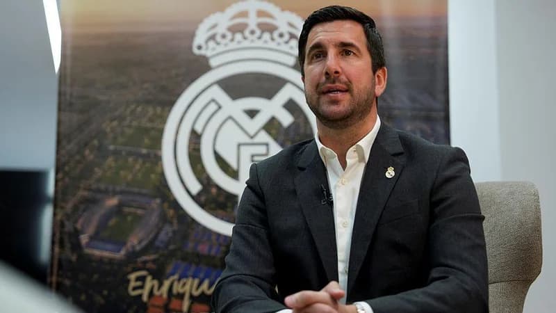 Spanish businessman Enrique Riquelme sits in front of a Real Madridn badge ahead of the club's presidential election, in which he is a candidate