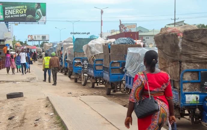 A queue of tricycles awaiting their turn in an alley towards the dumpsite