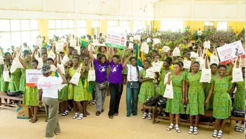 Tepa SHS School girls showcasing the sanitary pads distributed to them