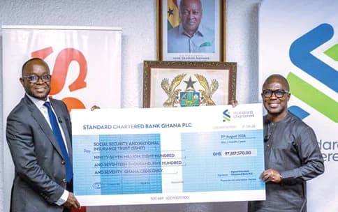 Xorse Godzi (left), CEO, Standard Chartered Bank Ghana PLC, presenting the dummy cheque to Kwesi Afreh Biney, Director-General of SSNIT