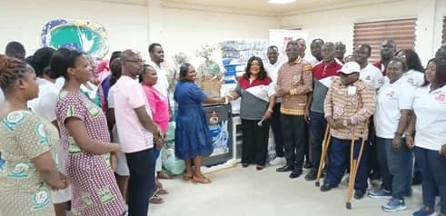 Akua Asantewaa Agyei, Deputy Chief Nursing Officer and Nursing Manager for the Newborn Unit and Kids Ward, receiving the items form Sylvia Ammoro, Chairperson of the Kascity District Society