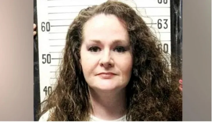 A mugshot of a woman with long, curly brown hair, identified in news reports as a death row inmate. She is posed against a height chart backdrop commonly used in law enforcement processing.