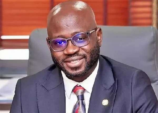 A portrait of Samuel Okudzeto Ablakwa, Member of Parliament for North Tongu and Ranking Member on the Foreign Affairs Committee. He is shown wearing a navy blue suit, a patterned tie, and eyeglasses while seated in a professional office setting.