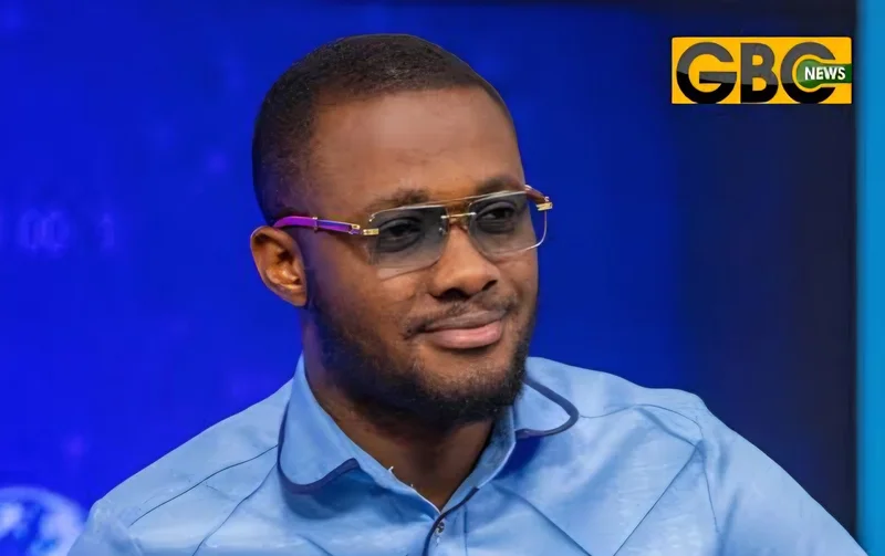 A close-up photograph of a man identified as cybersecurity expert David Gyedu, wearing gold-rimmed glasses and a light blue shirt. He appears to be in a television studio setting, as indicated by the 'GBC NEWS' logo in the top right corner and the blurred blue background.