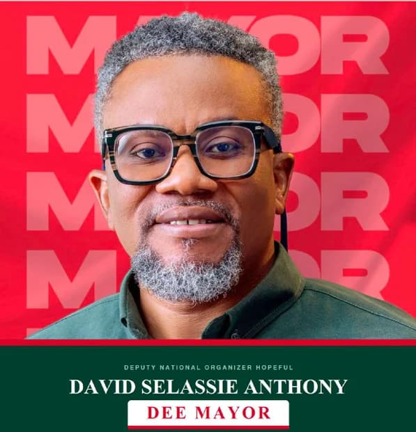 A political campaign flyer for David Selassie Anthony, featuring a portrait of him wearing glasses and a dark green shirt. The background is red with a repeating 'MAYOR' watermark, and a green banner at the bottom identifies him as a candidate for Deputy National Organiser.