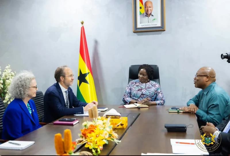 Vice President Jane Naana Opoku-Agyemang is pictured hosting a diplomatic meeting at a conference table in an official setting. She is joined by several officials, including the UK High Commissioner, with the Ghana national flag and an official portrait of President John Mahama visible in the background.