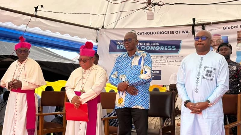 A photograph showing religious and civil leaders standing under a white canopy during the Global Rosary Congress in Wa. Two Catholic bishops in ceremonial magenta and white vestments are seen on the left, alongside two men in Ghanaian attire standing before a banner for the Catholic Diocese of Wa.