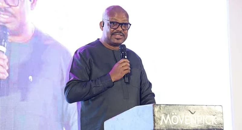 Director-General of the Ghana Ports and Harbours Authority (GPHA), Michael Luguje, speaks at a podium during the organization's 40th-anniversary celebration. He is seen wearing a dark kaftan and glasses, addressing an audience at the Mövenpick Ambassador Hotel in Accra.