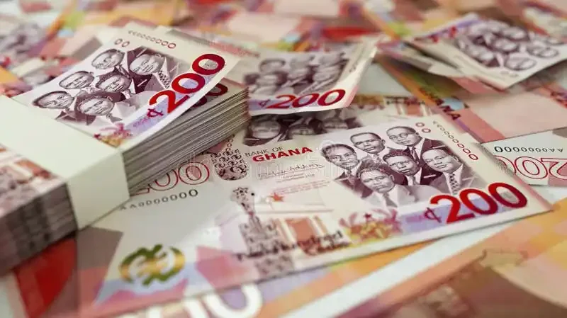 A close-up photograph showcasing several stacks and loose 200 Ghanaian Cedi banknotes. The notes clearly display the 'Big Six' founding fathers of Ghana and the 'BANK OF GHANA' text, representing the national currency.