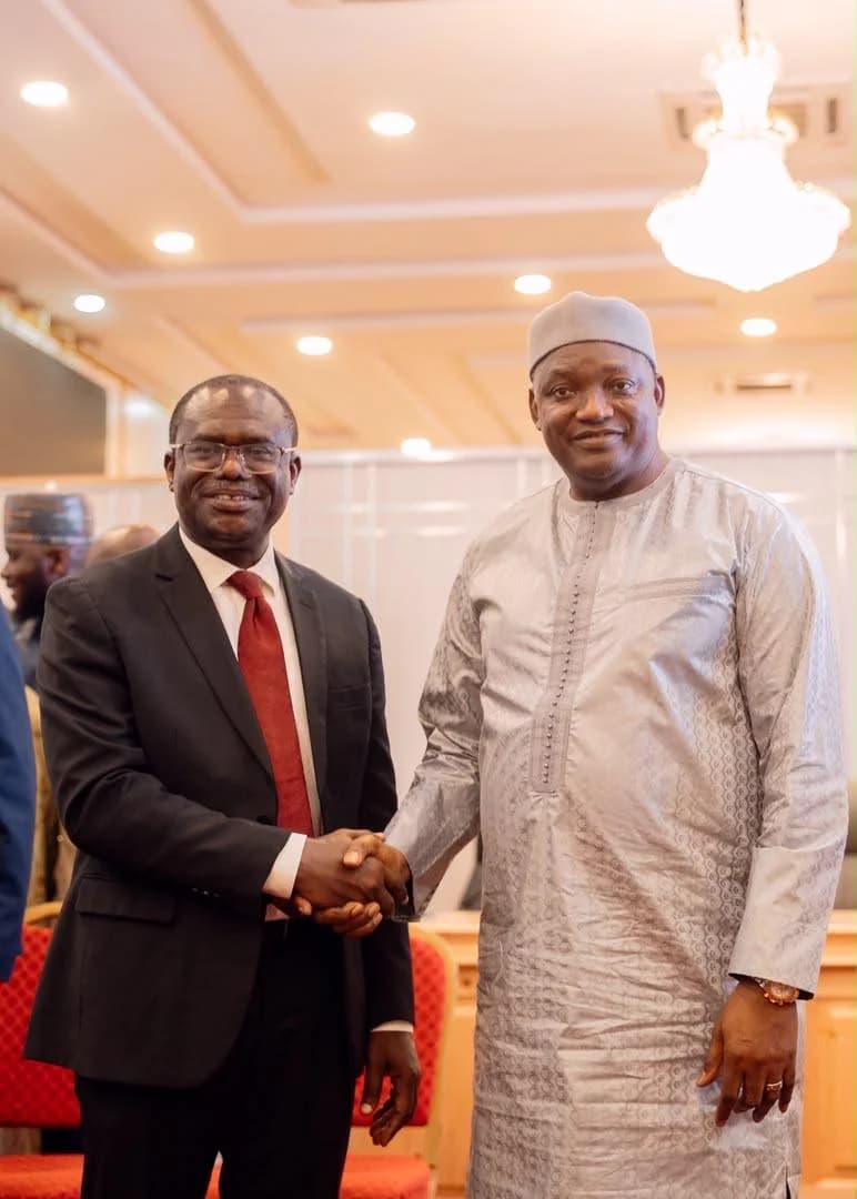President Adama Barrow of The Gambia and Dr. Joseph Siaw Agyepong, Executive Chairman of the Jospong Group (Zoomlion), are seen shaking hands in a formal indoor setting. The meeting marks a significant waste management agreement between the Gambian government and the Ghanaian conglomerate.