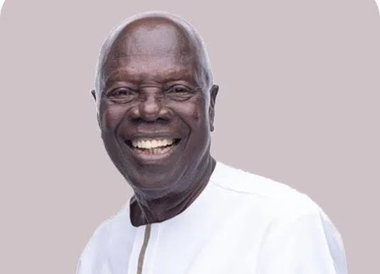 A close-up portrait of Dr. Ishmael Yamson, a prominent Ghanaian business leader, smiling broadly against a plain neutral background. He is wearing a white traditional Ghanaian garment with a tan vertical stripe detail at the neckline.